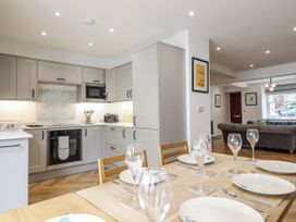 A kitchen with dining table and chairs at Neptune Cottage in Conwy