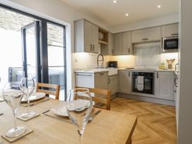 A kitchen with cabinets and appliances at Neptune Cottage in Conwy