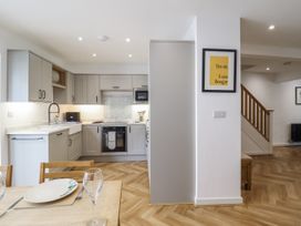 A kitchen with appliances and dining table at Neptune Cottage in Conwy