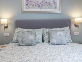 A bedroom with a bed and decorative pillows at Neptune Cottage in Conwy