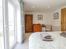 A bedroom with a bed and wardrobe at Neptune Cottage in Conwy