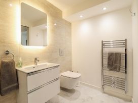 A bathroom with a sink and towel rack at Neptune Cottage in Conwy