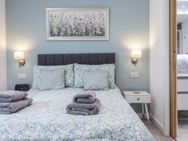 A bedroom with a bed and bedside table at Neptune Cottage in Conwy