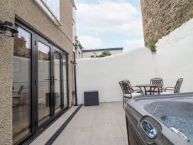 An outdoor area with a hot tub and seating at Neptune Cottage in Conwy