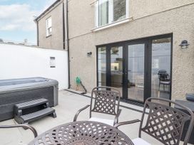 An outdoor area with a hot tub and a dining table at Neptune Cottage in Conwy
