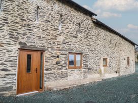 An exterior view of a stone building with wooden door and windows at Godre'r Gyrn, Plas Moelfre Hall Barns, Oswestry