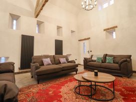 A living room with sofas, a coffee table, and a rug at Godre'r Gyrn, Plas Moelfre Hall Barns, Oswestry
