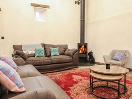 A living room with a fireplace and seating at Godre'r Gyrn, Plas Moelfre Hall Barns Oswestry
