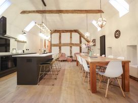 A kitchen with an island and dining table at Godre'r Gyrn, Plas Moelfre Hall Barns, Oswestry