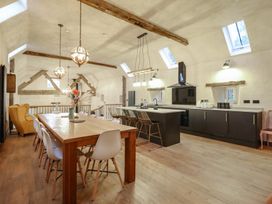 A kitchen with a dining table and chairs at Godre'r Gyrn, Plas Moelfre Hall Barns in Oswestry