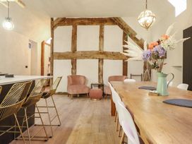 A dining room with a wooden table and bar stools at Godre'r Gyrn, Plas Moelfre Hall Barns, Oswestry