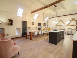 An open plan kitchen and dining area with a table and chairs at Godre'r Gyrn, Plas Moelfre Hall Barns, Oswestry