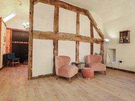 A living room with two chairs and a small table at Godre'r Gyrn, Plas Moelfre Hall Barns in Oswestry