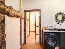 A laundry room with a washing machine and sink at Godre'r Gyrn, Plas Moelfre Hall Barns in Oswestry
