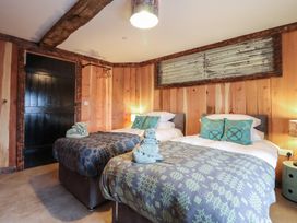 A bedroom with two beds and decorative towels at Godre'r Gyrn, Plas Moelfre Hall Barns, Oswestry