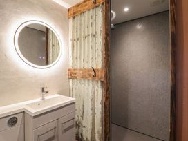 A bathroom with a sink and mirror at Godre'r Gyrn, Plas Moelfre Hall Barns in Oswestry