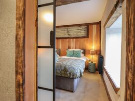 A bedroom with a bed and bedside table at Godre'r Gyrn, Plas Moelfre Hall Barns, Oswestry