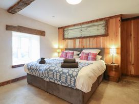 A bedroom with a bed and nightstand at Godre'r Gyrn, Plas Moelfre Hall Barns, Oswestry