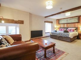 A bedroom with a double bed and sofa at Godre'r Gyrn, Plas Moelfre Hall Barns Oswestry