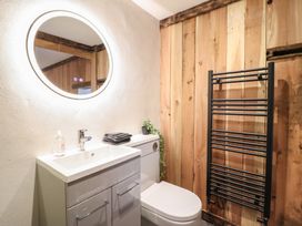 A bathroom with a sink, toilet, and towel rack at Godre'r Gyrn, Plas Moelfre Hall Barns, Oswestry