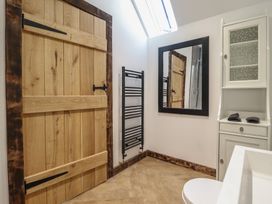 A bathroom with a cabinet and mirror at Godre'r Gyrn, Plas Moelfre Hall Barns in Oswestry