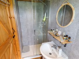 A bathroom with a sink mirror and glass shower at Moel Y Parc in Bryniau Clwyd near Denbigh