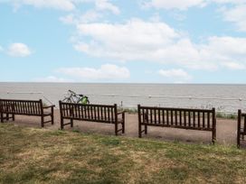 A view of benches near the sea with a bike at Astondene, East Cliff in Southwold