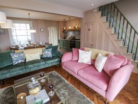 A living room with a green sofa and pink sofa at Astondene, East Cliff in Southwold
