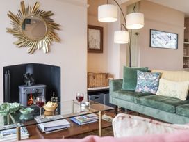 A living room with a green sofa and a coffee table at Astondene, East Cliff Southwold