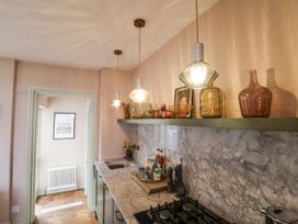 A kitchen with a sink and light fixtures at Astondene, East Cliff Southwold