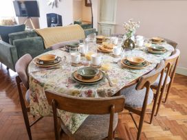 A dining room with a table set for a meal at Astondene, East Cliff, Southwold