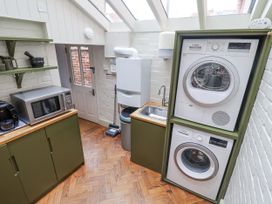 A utility room with washing machine and dryer at Astondene, East Cliff, Southwold