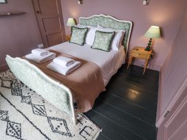 A bedroom with a bed and nightstand at Astondene, East Cliff Southwold