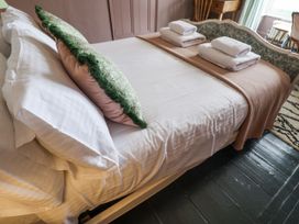 A bedroom with a bed and towels at Astondene, East Cliff, Southwold