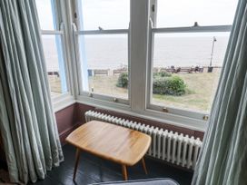 A living room with a table and view of the sea at Astondene, East Cliff Southwold