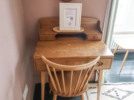 A wooden desk and chair with a framed information booklet at Astondene, East Cliff Southwold