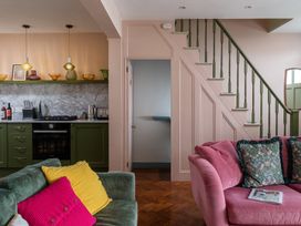 A living room with a kitchen area and staircase at Astondene, East Cliff, Southwold
