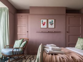 A bedroom with a bed and a chair at Astondene, East Cliff in Southwold