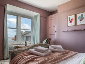 A bedroom with bed towels and windows at Astondene, East Cliff in Southwold
