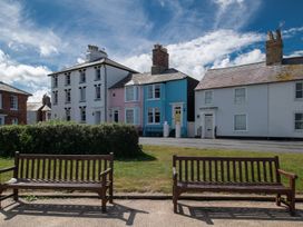 Houses with colorful exteriors and benches in front at Astondene, East Cliff in Southwold