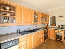 A kitchen with wooden cabinets and appliances at Harbourside in Dartmouth