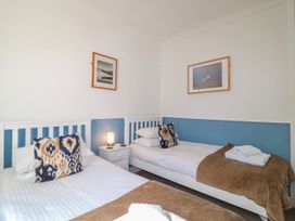 A bedroom with two beds and a lamp at Harbourside in Dartmouth