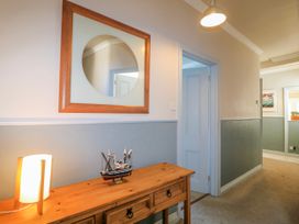 A hallway with a mirror and a model ship on a table at Harbourside in Dartmouth