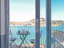 A balcony with a table and chairs overlooking a water view at Harbourside in Dartmouth