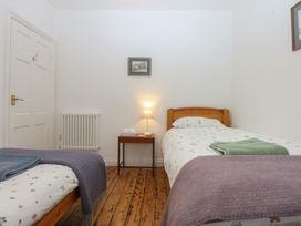 A bedroom with two beds and a bedside table at Chandos in Dolwyddelan