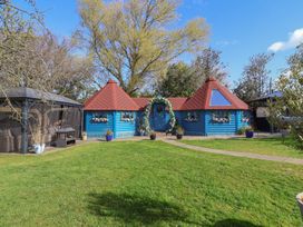 A blue cottage with a red roof and garden at Applejacks Orchard in Holywell