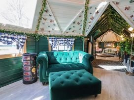 A living room with a sofa and ottoman at Applejacks Orchard in Holywell