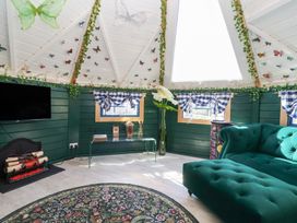 A living room with a sofa and television at Applejacks Orchard in Holywell