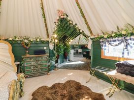 A bedroom with decorative plants and a chest of drawers at Applejacks Orchard in Holywell