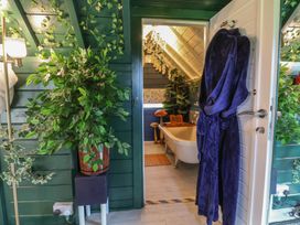 A bathroom with a bathtub and plants at Applejacks Orchard in Holywell